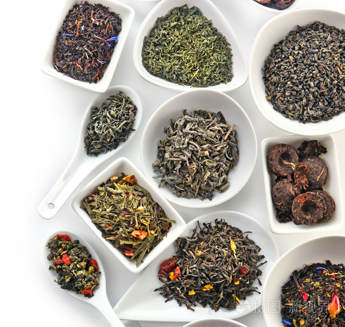 各种各样的碗和勺子上白色孤立的干茶叶