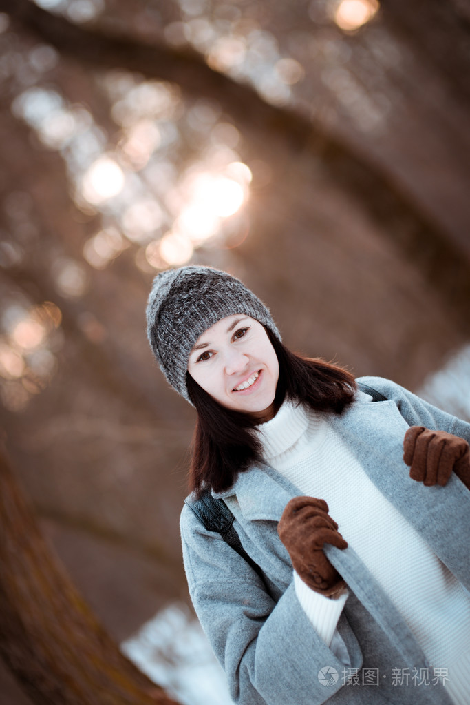 肖像的棕色的头发,冬季的森林里快乐的美丽女孩穿着时髦风格的生活