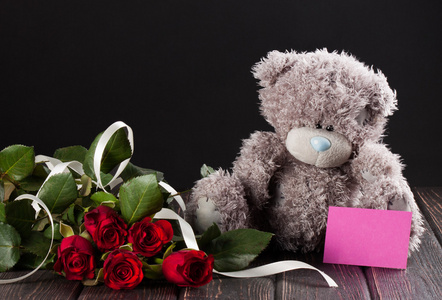 泰迪熊和卡在木头上的玫瑰花
