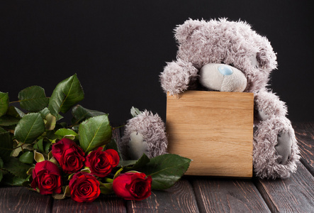 泰迪熊和卡在木头上的玫瑰花