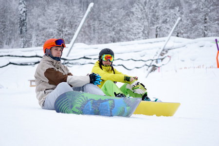 两个滑雪板男人和女人坐在山中