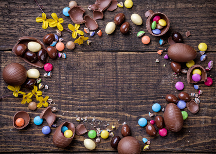巧克力复活节彩蛋和糖果上木制背景