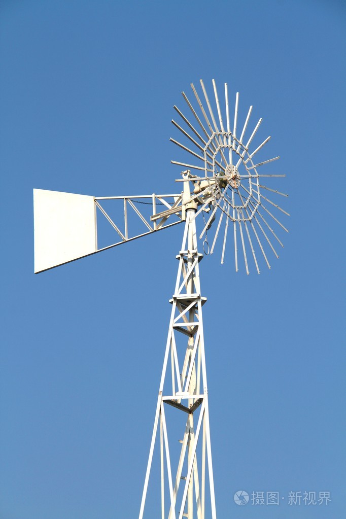 抽水风车在蓝蓝的天空背景上的白色水
