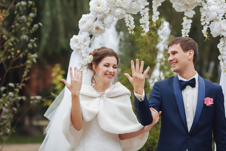 时尚的新娘和新郎是背景上的交换戒指。