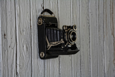 旧旧的木墙上挂着的相机