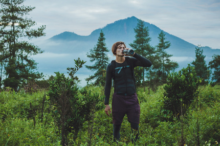 室外肖像的年轻人看巴图尔火山和阿贡