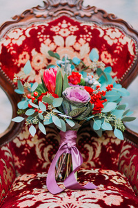 巧妙地装饰婚礼花束在红色的老式靠背椅