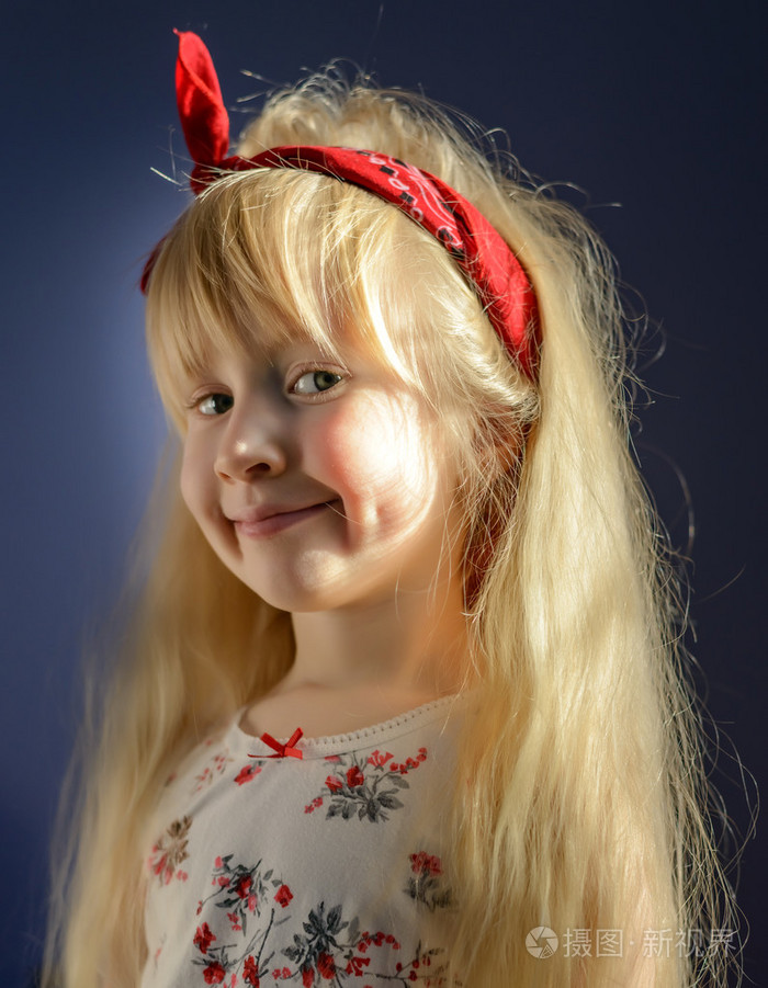 灰色背景的金发小女孩微笑着