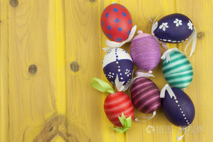 彩色复活节彩蛋在一个古老的黄色木制背景。 庆祝活动