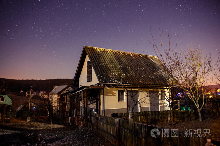 在夜晚的星空背景上的木房子里