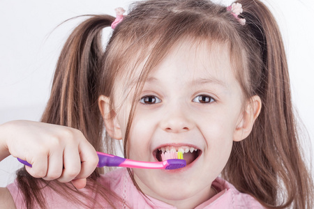 口腔卫生。快乐的小女孩，她刷牙。分离