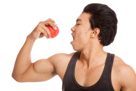 弯曲与红苹果的二头肌肌肉亚洲男照片