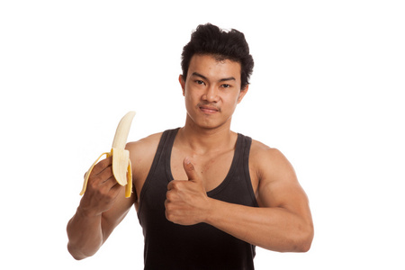 肌肉发达的亚洲人竖起大拇指与去皮的香蕉照片