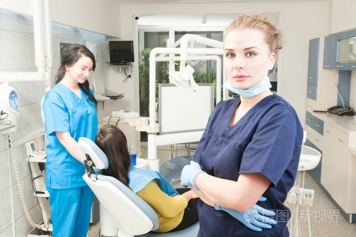 女医生与背景的年轻助手牙科团队