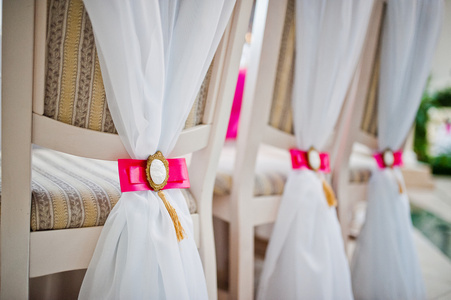 婚礼椅子与粉红色的蝴蝶结和胸针