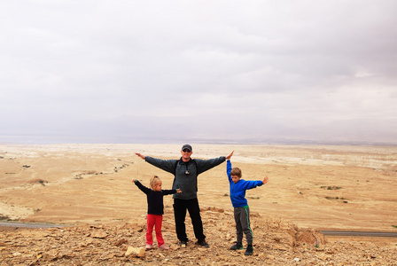 父亲和孩子们在沙漠中徒步旅行