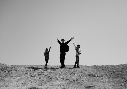 父亲和孩子们在沙漠中徒步旅行