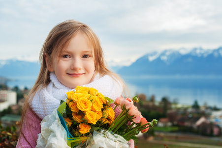 春天的可爱孩子的小姑娘用鲜花的肖像