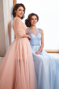 两个豪华漂亮的双胞胎年轻妇女的服装，柔和的色彩。美容时尚肖像
