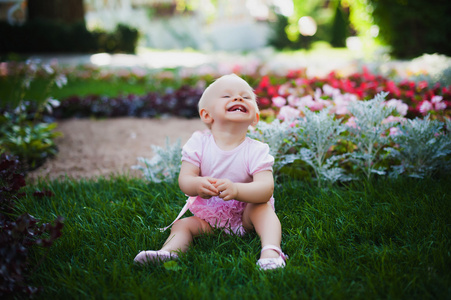 微笑肖像可爱的宝贝女孩在绿色草地上