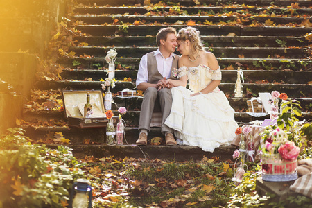 新娘和新郎在拥抱上的复古风格的石阶，可以使设备在秋天的树林，包围婚礼装饰
