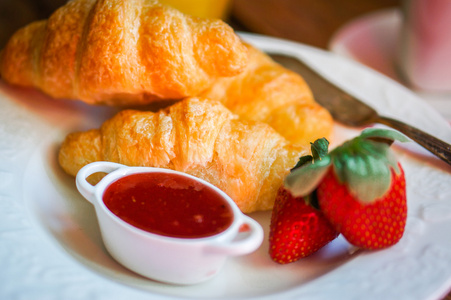 美味早餐  ccroissants 草莓果酱上木制黑色