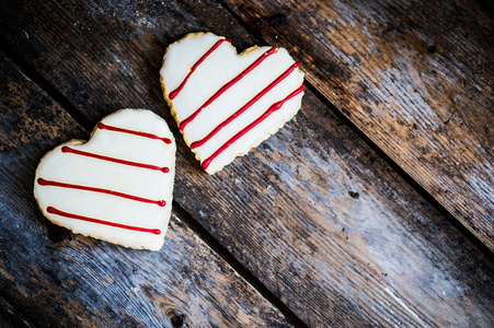 质朴的木制背景上的白色和红色心饼干