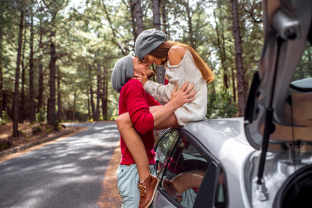 一对年轻夫妇开车在森林里旅行