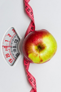 用卷尺在体重秤上的苹果。节食