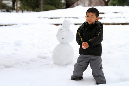 打雪仗和堆雪人的日本男孩4岁