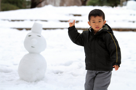 打雪仗和堆雪人的日本男孩4岁