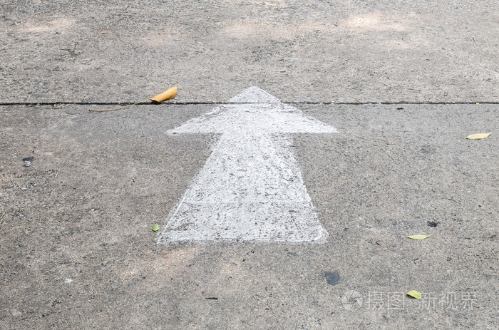 特写镜头白色画的箭头标志在水泥街道地板背景