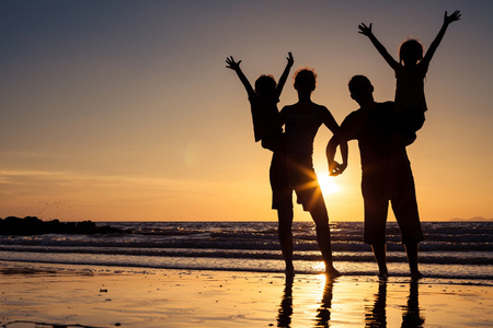 幸福的家庭剪影谁站在沙滩上的太阳