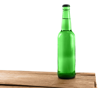 木制的桌子，白色背景上的绿色玻璃啤酒瓶