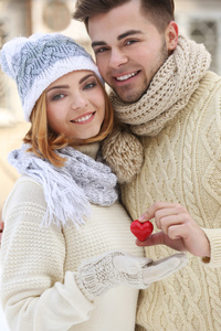 爱在冬天在户外举行小红心对年轻夫妇