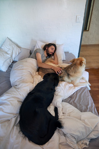 男子躺在床上抚摸着他的狗