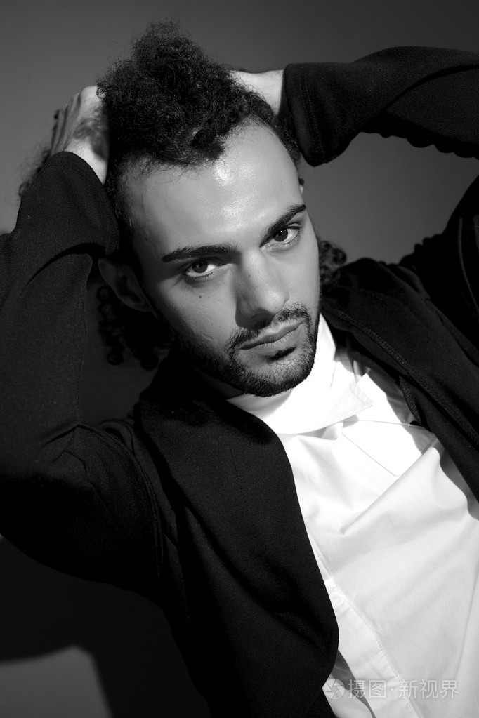 时尚男模特拿着卷曲的头发黑白肖像