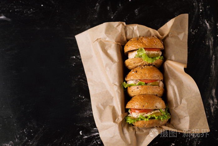 在黑暗的背景下,在工艺中,三个汉堡查看从上面