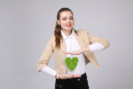 她手里拿着绿色的植物心的女人