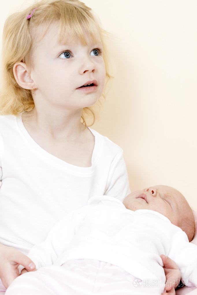 小女孩抱着她一个月大的婴儿妹妹