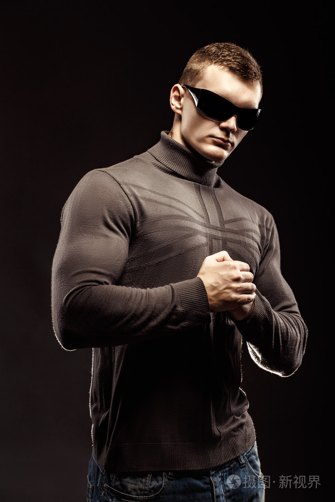打击肌肉的动作英雄人穿件衬衫配裤子和太阳镜.工作室拍摄.战警风格