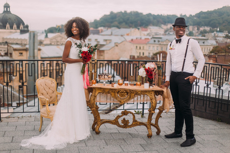幸福的黑人新婚夫妇在我们附近的露台上幸福地微笑