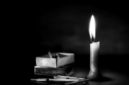 蜡烛和火柴盒在漆黑的夜晚照片