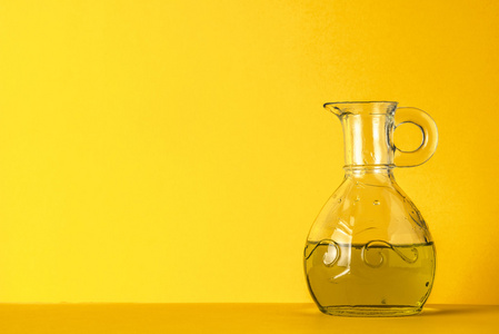 橄榄油在黄色背景上的玻璃罐子里