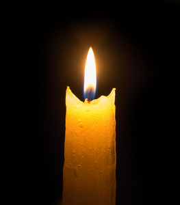 黑暗中的光亮一支蜡烛在黑暗中的光亮的火焰照片
