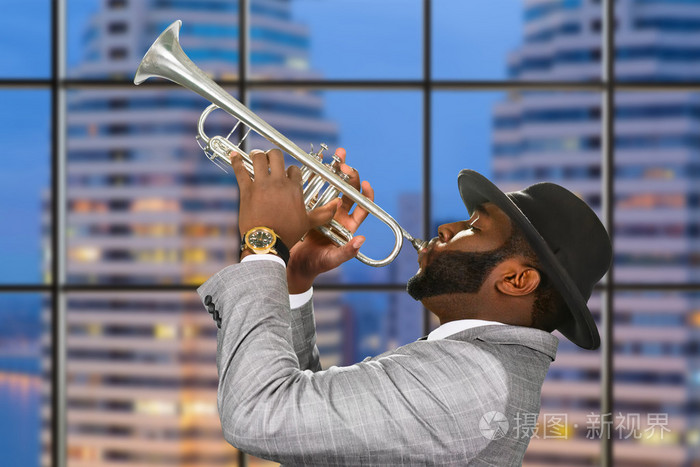 在城市背景下的黑人小号手