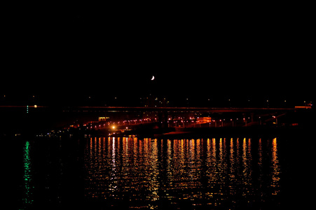 月亮下的桥。夜晚的城市灯光。城市夜景。