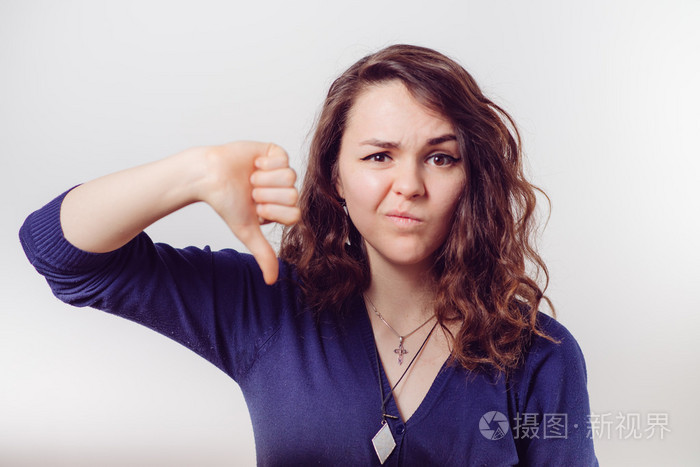 显示一个拇指下的手势的女人