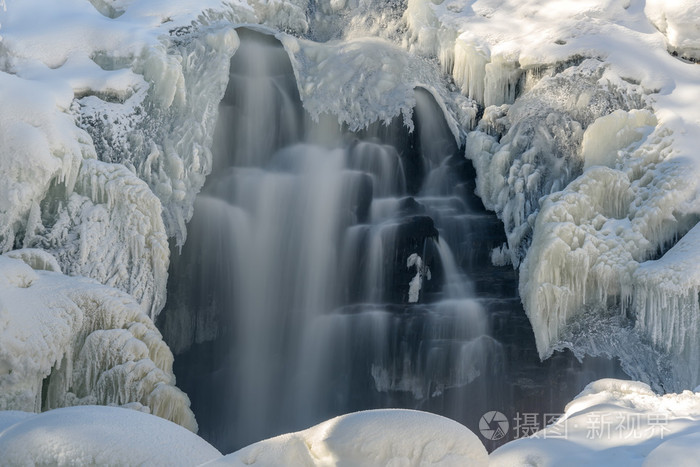 在瀑布上的风景，有美丽的冷冻水图案，冬天有水冰和雪堆