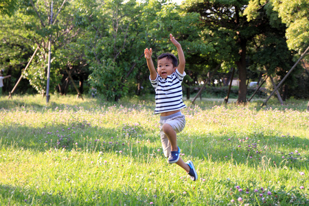在草地上奔跑的日本男孩(4岁)照片